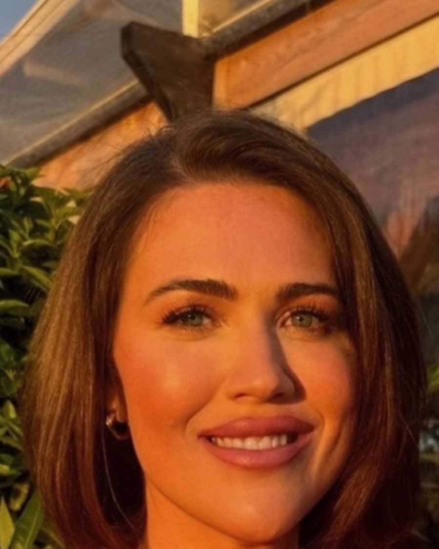 Rachann McKnight, a People and Operations executive, in a warm golden-hour portrait wearing a red top with a warm smile.